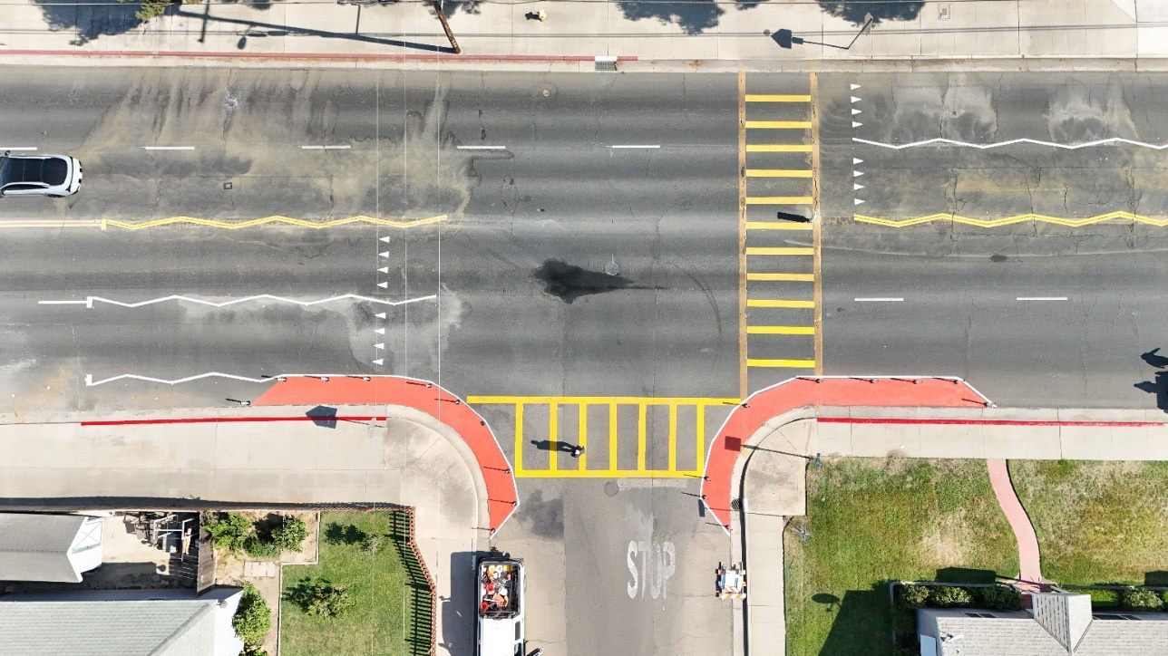 Aerial view of red painted curb extensions and zig-zag markings at an intersection