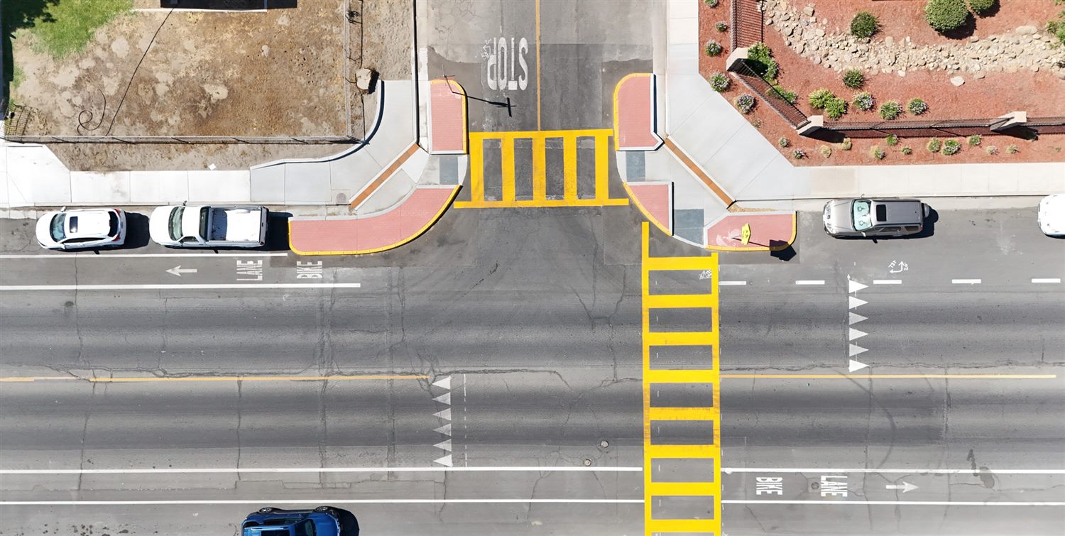 Aerial view of a complete-streets intersection with crosswalks, bike lanes, and curb extensions